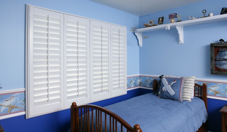 Blue kids bedroom with white plantation shutters in Gainesville 